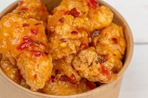 Panda Express style orange chicken in a takeout bowl